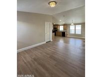 Open-concept living room and kitchen with wood-look flooring and natural light at 6839 W Taylor St # 209, Phoenix, AZ 85043
