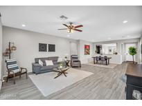 Spacious living room features modern décor, plush seating, and an open floor plan to the dining area at 7070 W Andrea Dr, Peoria, AZ 85383