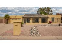 Charming single-story home with a tiled roof, desert landscaping, and a secure gated entry for added privacy at 7252 E Edgewood Ave, Mesa, AZ 85208