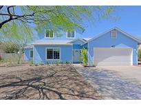 Charming two-story home featuring a well-maintained front yard and a cozy covered entrance, with a large driveway at 16256 N 64Th Pl, Scottsdale, AZ 85254