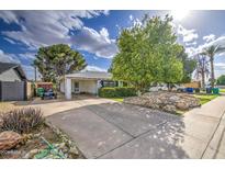 Charming single-story home with a well-maintained front yard and a long driveway with a covered carport at 1849 E Jarvis Ave, Mesa, AZ 85204
