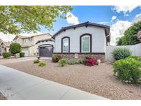 Charming single-story home with well-maintained landscaping, flowerbeds, and a quaint facade at 20017 S 192Nd Pl, Queen Creek, AZ 85142