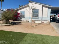 Charming home featuring low-maintenance desert landscaping with a colorful bush and a quaint tree in the front yard at 2028 E Libby St, Phoenix, AZ 85022