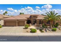 Beautiful single-story home showcasing manicured landscaping, a spacious three-car garage, and gated entry at 20609 N Canyon Whisper Dr, Surprise, AZ 85387