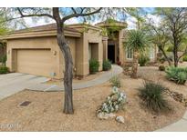 Charming single-story home features a neutral color palette, desert landscaping, and an attached two-car garage at 33269 N 73Rd Pl, Scottsdale, AZ 85266