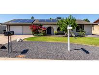 Charming single-story home with solar panels, low-maintenance landscaping, and a welcoming arched entryway at 3516 W Brown St, Phoenix, AZ 85051