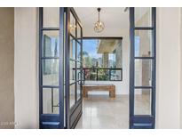 Grand entryway with tile floors, modern light fixture and picturesque desert views at 38199 N Tranquil Way, Carefree, AZ 85377