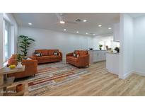 Bright living room with modern furnishings, wood floors, and an open floor plan to the kitchen at 4109 N 30Th Ave, Phoenix, AZ 85017