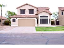 Charming two-story home featuring a tile roof, neutral stucco, and a well-manicured lawn at 488 W Harvard Ave, Gilbert, AZ 85233