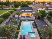 Expansive backyard boasts a sparkling pool, putting green, outdoor seating, and a firepit for memorable entertaining at 6301 N 16Th Dr, Phoenix, AZ 85015
