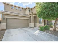 Two-story home with a neutral color scheme, well-maintained landscaping, and an attached two-car garage at 6749 W Charter Oak Rd, Peoria, AZ 85381
