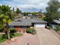 Charming brick home featuring a well-maintained yard, two-car garage and desert landscaping at 8204 E Turney Ave, Scottsdale, AZ 85251