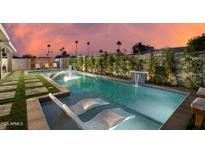 Inviting backyard pool featuring stylish lounge chairs and lush landscaping, perfect for relaxing evenings at 8229 E Devonshire Ave, Scottsdale, AZ 85251