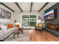 Living room with natural light, a fireplace, and seamless indoor-outdoor flow to the backyard pool at 8431 E Rose Ln, Scottsdale, AZ 85250