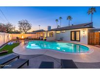 Inviting backyard pool with lounge chairs, fire pit, and privacy fence, perfect for evening relaxation at 8431 E Rose Ln, Scottsdale, AZ 85250