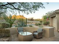 Cozy patio seating area features comfortable wicker furniture and a view of the natural desert landscape at 10040 E Happy Valley Rd # 2022, Scottsdale, AZ 85255
