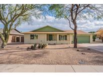 Charming single-story home with desert landscaping, a green roof, and a matching garage door at 1237 E Gemini Dr, Tempe, AZ 85283