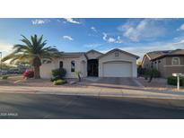 Charming single-story home boasts a stucco facade, arched entryway, attached garage, and desert landscaping at 17946 W Buena Vista Dr, Surprise, AZ 85374