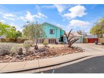 Charming two-story home with a manicured front yard featuring rock landscaping and mature trees at 1822 N Sunaire Cir, Mesa, AZ 85205