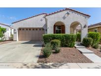 Charming single-story home with neutral stucco, arched entryway, red tile roof and two-car garage at 20698 W Meadowbrook Ave, Buckeye, AZ 85396
