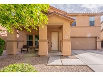 Inviting home featuring a charming front porch, two-car garage, and low maintenance desert landscaping at 2939 W Sunshine Butte Dr, San Tan Valley, AZ 85144