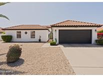 Charming single-story home with a well-maintained front yard, desert landscaping and a black garage door at 5719 E Paradise Ln, Scottsdale, AZ 85254