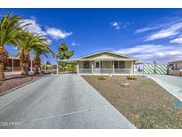 Charming single-story home featuring a front porch, covered parking, and desert landscaping at 67 S Amulet Ave, Mesa, AZ 85208
