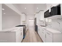 Bright kitchen featuring white cabinets, stainless steel appliances, and marble countertops at 7041 E Cypress St St, Scottsdale, AZ 85257
