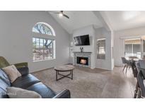 Bright living room with vaulted ceilings, modern fireplace, and a large window showcasing desert views at 7675 E Mcdonald Dr # 107, Scottsdale, AZ 85250