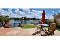 Inviting backyard with stone patio, outdoor seating, artificial turf and lake views at 8935 W Acoma Dr, Peoria, AZ 85381