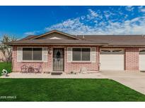Charming single-story brick home with a well-manicured lawn and attached garage, offering comfortable living at 9816 N 95Th Dr # A, Peoria, AZ 85345