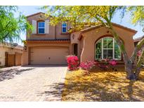 Charming two-story home featuring a well-manicured front yard and a two car garage at 13749 W Amberwing St, Peoria, AZ 85383