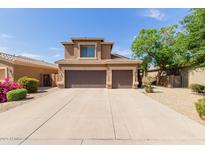 Two-story home with three-car garage and a well-maintained, xeriscaped front yard in a suburban neighborhood at 16228 W Crocus Dr, Surprise, AZ 85379