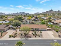 Charming single-story home featuring desert landscaping and a spacious driveway, set against a backdrop of scenic mountains at 2315 E Cholla St, Phoenix, AZ 85028