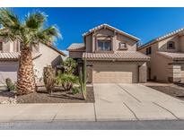 Charming two-story home featuring a desert landscape, two car garage and a terracotta tile roof at 4128 E Coolbrook Ave, Phoenix, AZ 85032