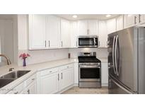 Stylish kitchen features stainless steel appliances, white cabinetry, and light countertops at 5350 E Deer Valley Dr # 2435, Phoenix, AZ 85054