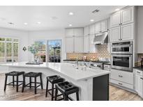 Spacious kitchen featuring a large island with seating and stainless steel appliances at 8235 E Sierra Pinta Dr, Scottsdale, AZ 85255