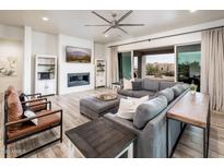 Spacious living room with a modern fireplace, comfortable seating, and view of the outside landscape at 15223 E Lone Mountain Rd, Scottsdale, AZ 85262
