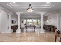 Spacious game room featuring a pool table, comfortable seating, and large windows at 16465 W Mohave St, Goodyear, AZ 85338