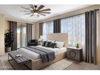 This primary bedroom features a ceiling fan, sitting area, and lots of natural light from the window at 2408 W Crimson Ter, Phoenix, AZ 85085