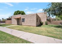 Charming single-story home showcasing a stucco exterior, small front yard, and tiled awning over the front door at 600 S Dobson Rd # 67, Mesa, AZ 85202