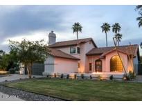 Charming pink two-story home with a tile roof, landscaped yard, and picturesque palm trees at 10266 E Caron St, Scottsdale, AZ 85258