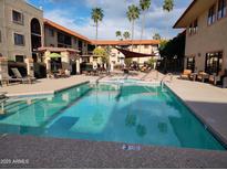 Community swimming pool surrounded by lounge chairs offering a relaxing outdoor experience at 10330 W Thunderbird Blvd # C-228, Sun City, AZ 85351