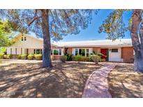 Charming single-story home with brick accents, surrounded by well-manicured landscaping and mature trees, creating a welcoming curb appeal at 4350 E Vermont Ave, Phoenix, AZ 85018