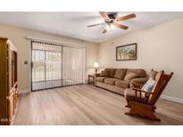 Relaxing living room with wood floors, ceiling fan, and sliding doors to the backyard at 1021 S Greenfield Rd # 1194, Mesa, AZ 85206