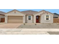 Charming single-story home with a two-car garage, red door and desert landscaping at 14742 W Lariat Trl, Surprise, AZ 85387