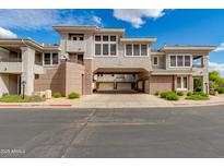 Inviting exterior of a multi-story townhome featuring stucco and a covered car port against a backdrop of blue sky and clouds at 15221 N Clubgate Dr # 2132, Scottsdale, AZ 85254