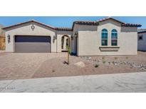 Inviting single-story home with desert landscaping, two-car garage, and arched entryway at 18150 W Tanglewood Dr, Goodyear, AZ 85338