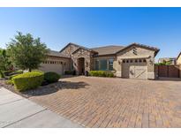 Charming single-story home with a three-car garage, stone accents, and a brick driveway at 22302 E Russet Rd, Queen Creek, AZ 85142