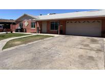 Charming single story home with a well manicured lawn, spacious driveway, and a one car garage at 3020 N 64Th Dr, Phoenix, AZ 85033